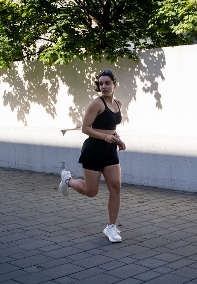 Sujetando un sujet con un sujet negro, el fondo es una pared de color claro y un follaje verde.