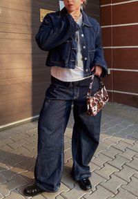 Tumesinine teksajakk ja laiad teksapüksid. All on valge T-särk. Pruun ja valge mustriga käekott. Läikivad mustad kingad. Igapäevane outfit.