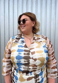 Motýlové šaty v několika barvách s kombinací modrých, hnědých a krémových batikovaných vzorů; lehká látka s detailem na stažení v pase.