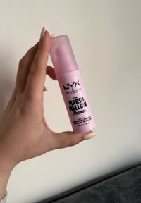 Rosa bomba de plástico etiquetada "NYX Professional Makeup The Marsh Mellow Primer", con texto negro y una tapa transparente. 30 ml.