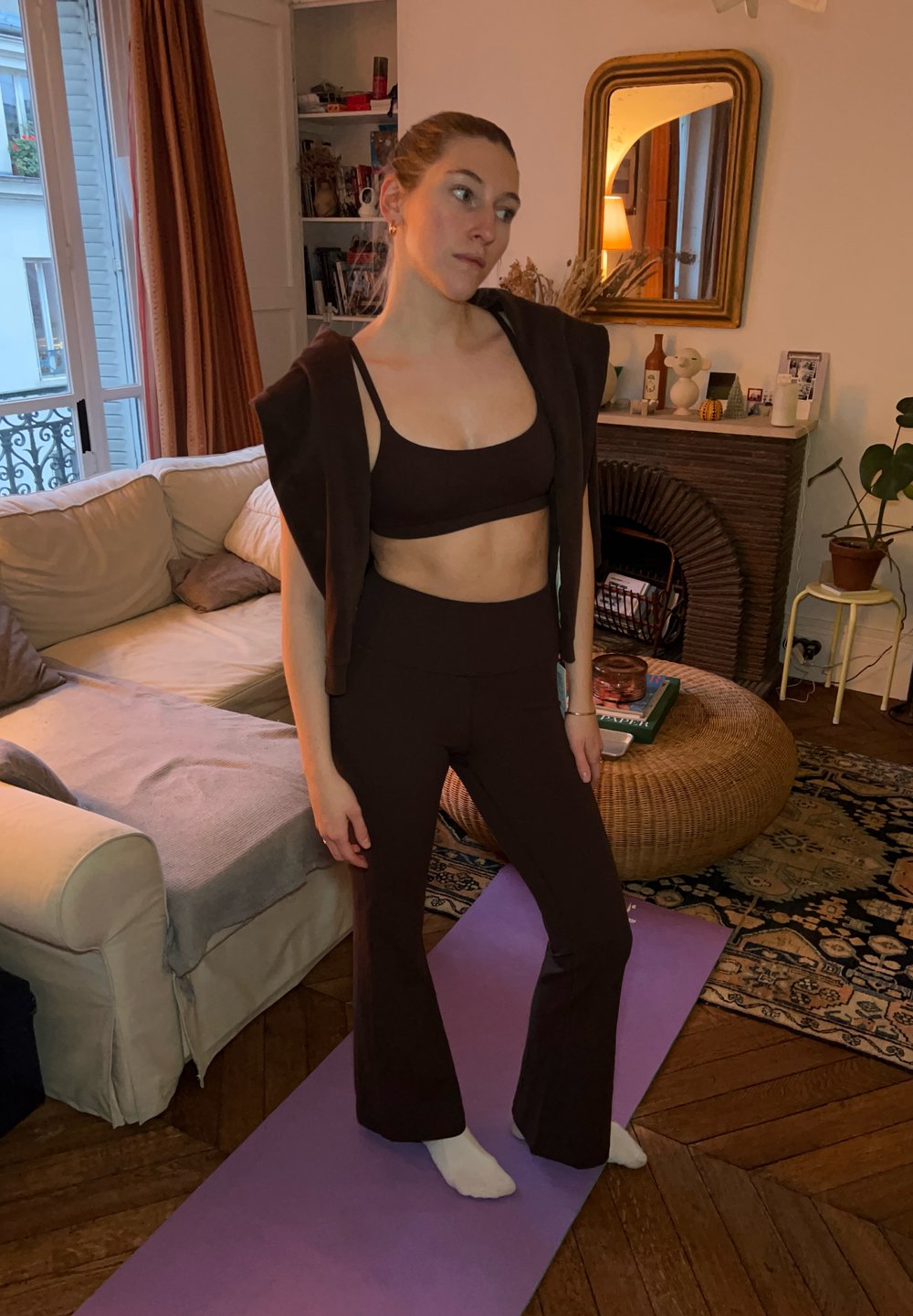 Brunt aktivt tøj sæt med en cropped top og højtaljede flagrende bukser, lavet af elastisk materiale. Simpelt design uden mønstre.