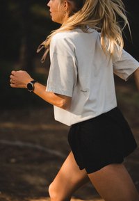 Lys grå kortermet t-skjorte sammen med svarte shorts. Skjorten har et sentrert logo, og shortsen har en løs og behagelig passform.