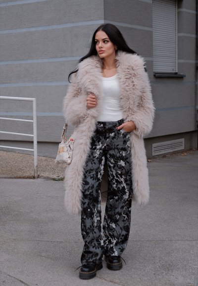 Larga chaqueta de pelo sintético en suave color beige, blusa blanca, pantalones palazzo de patrón floral negro y zapatos de plataforma gruesa negros. Incluye bolsa cruzada.