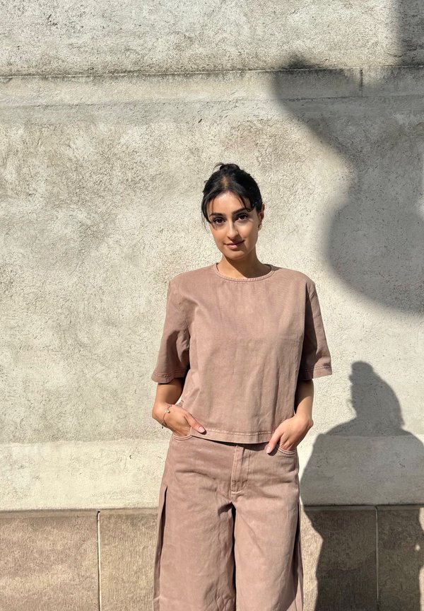 Light brown linen outfit featuring a short-sleeve top and wide-leg pants. Simple design and texture with front pockets and visible seams.