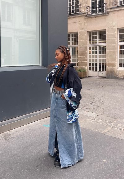 Falda larga de mezclilla con una abertura frontal, combinada con un top corto negro y un kimono negro con patrones de olas azules y mangas oversized.