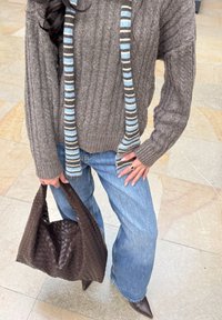 Ruskea neulottu neulepaita, jossa ribbineulos, sininen raidallinen huivi, vaaleansiniset farkut, punottu ruskea käsilaukku ja ruskeat teräväkärkiset korkokengät.