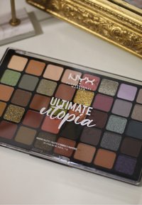 Paleta cieni do powiek NYX Ultimate Utopia zawierająca 40 odcieni, w tym mieszankę matów, połyskujących i brokatowych w ziemistych oraz szlachetnych tonach.