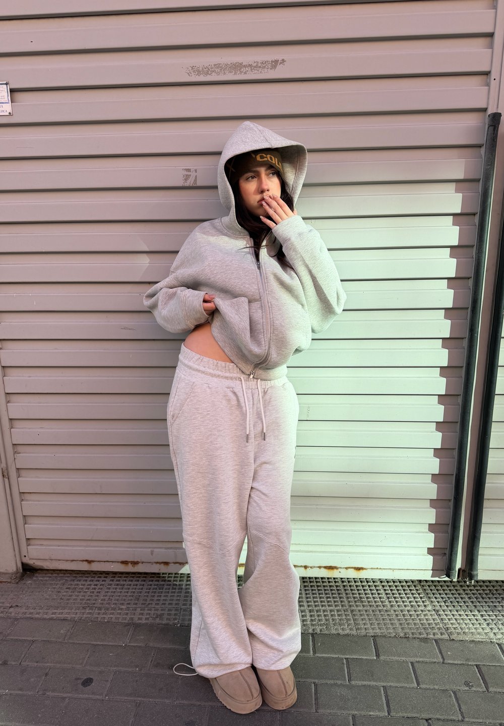 Sweat à capuche gris zippé avec une grande capuche, assorti à un pantalon de jogging assorti. Tissu doux avec une coupe décontractée, doté d'un cordon de serrage et de poches latérales.