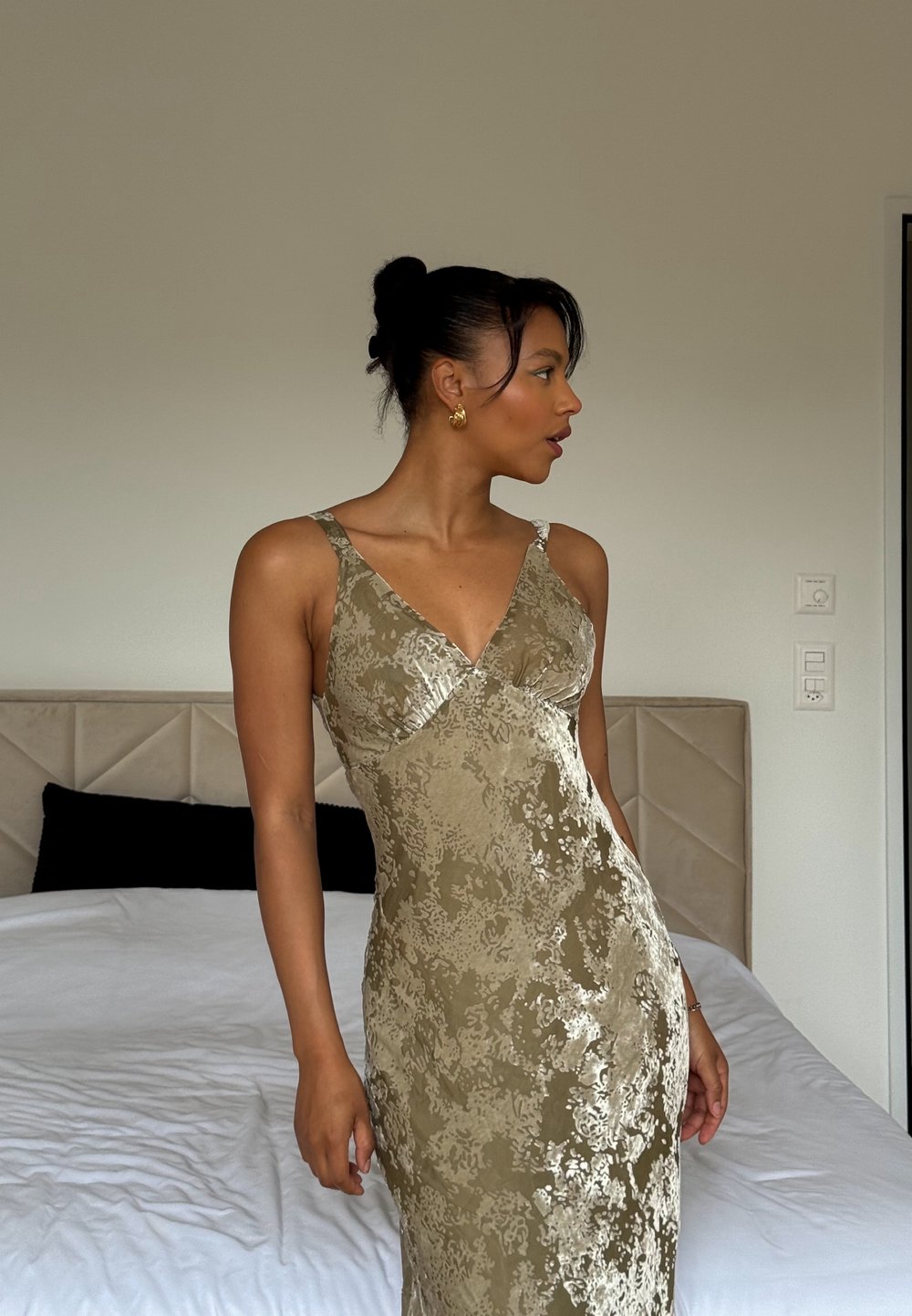 Robe moulante vert olive avec un motif en dentelle florale et un décolleté en V. Présente des bretelles fines et une texture lisse.