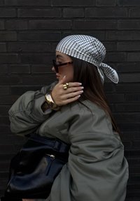 Roheline pommertagi suurte varrukatega, valge täpikate sall, üleliigne kilpkonnakilbi prillid, kuldsed käevõrud ja must käekott.