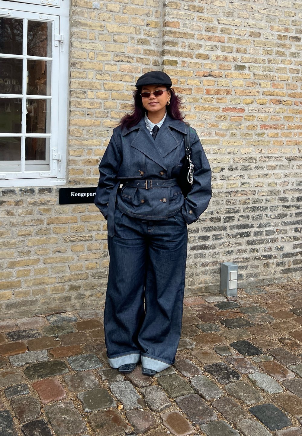 Denim trenchcoat med bred krage, belted midje og store lommer, kombinert med oversized denimbukser med oppbrettede cuffs.
