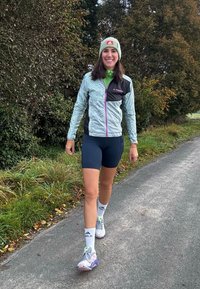 Ελαφρύ, μοτίβο σακάκι σε πράσινους και μαύρους τόνους, συνδυασμένο με σκούρες κοντές παντελόνες. Αθλητικά παπούτσια με παστέλ λεπτομέρειες, λευκές κάλτσες και σκουφάκι.