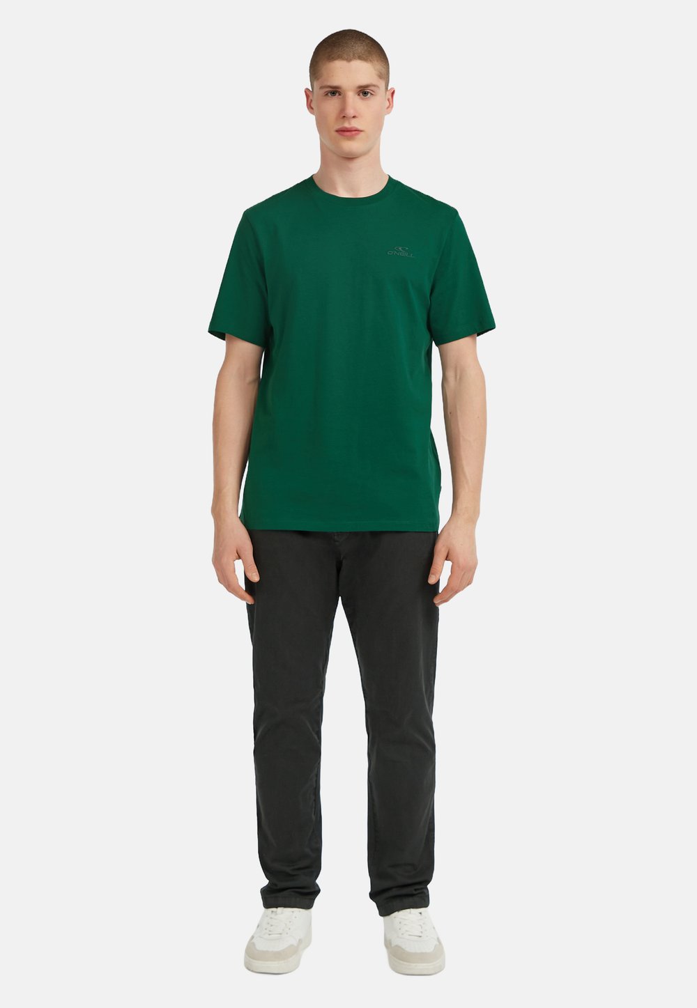 Zaļa īsām piedurknēm T-krekls, izgatavots no kokvilnas, ar apaļu kakla izgriezumu un mazu logotipa detaļu kreisajā krūtī. Valkāts ar melniem biksēm un baltām kurpēm.