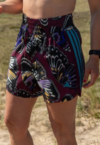 Calções roxos com um padrão de borboletas em tons de preto, branco e azul; cintura elástica; tecido suave; design leve.