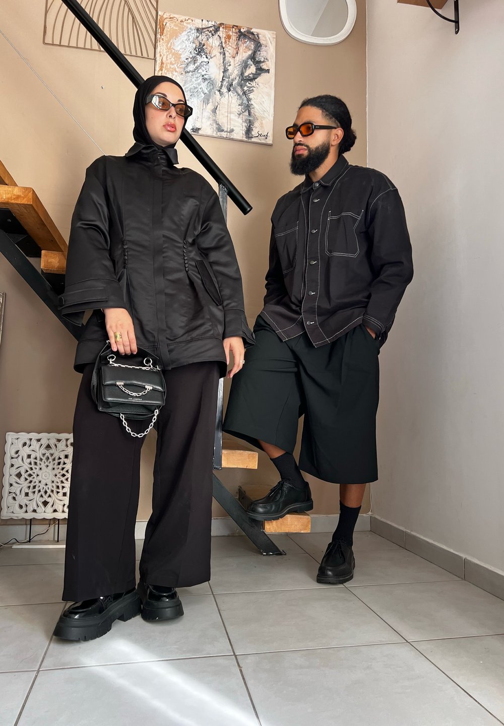 Μαύρο oversized σακάκι με δομημένα μανίκια, συνδυασμένο με φαρδύ παντελόνι και μια μικρή μαύρη τσάντα. Σκοτεινά γυαλιά ηλίου και χοντρές μπότες.