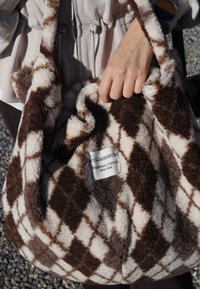 Bruine en crème geruite pluche handtas met een zachte textuur, met een label waarop staat "WILLIAMSBURG BEDFORD AVENUE NEW YORK."