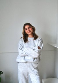Grauer Sweatshirt aus Baumwolle mit überschnittenen Schultern, langen Ärmeln und gerippten Bündchen. Kombiniert mit passenden grauen Jogginghosen mit seitlichen Nähten.