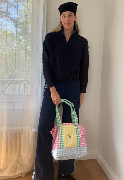 Bolso tote a cuadros multicolores en rosa, verde, amarillo y azul, con dos asas y un detalle de logo, hecho de una tela ligera.