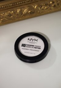 NYX HD Finishing Powder in einem runden schwarzen Compact. Weißes Etikett mit schwarzem Text. Mineralbasiert, Gewicht 0.28 oz (8 g).