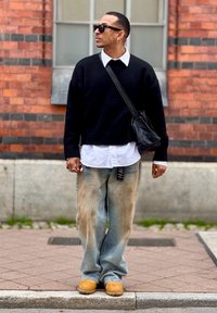 Sort strikket sweater, hvid skjorte med knapper, falmede løse jeans med en lappe og brune klipklappere. Accessory: lille sort crossbody taske.