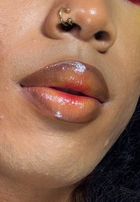 Gros plan sur des lèvres recouvertes d'une couleur à lèvres brillante et dégradée, passant d'un orange profond à un rose, avec une texture brillante et un éclat mis en valeur.
