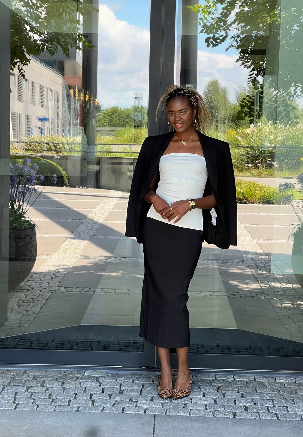 Μαύρο σακάκι πάνω από λευκή strapless μπλούζα, συνδυασμένο με μαύρη μινι φούστα και τακούνια με λεοπάρ σχέδιο. Απαλά υφάσματα και εφαρμοστό σχέδιο.