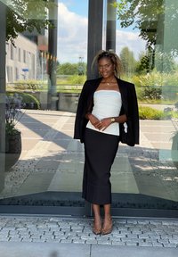 Μαύρο σακάκι πάνω από λευκή strapless μπλούζα, συνδυασμένο με μαύρη μινι φούστα και τακούνια με λεοπάρ σχέδιο. Απαλά υφάσματα και εφαρμοστό σχέδιο.