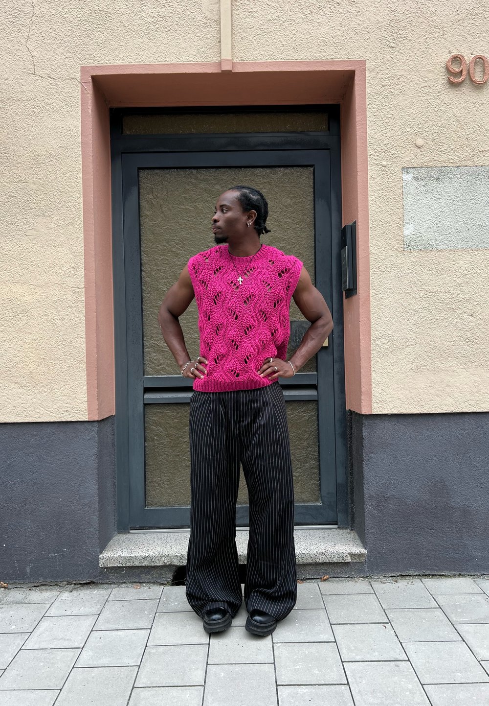 Κίτρινο αμάνικο τοπ σε φωτεινό ροζ με ανοιχτό σχέδιο, συνδυασμένο με φαρδιά παντελόνια μαύρες ρίγες και χοντρά μαύρα υποδήματα.