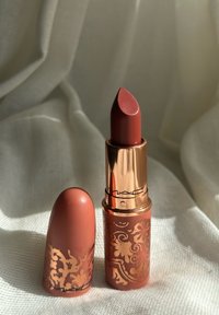Matt coral leppestift i en gullkantet tube med utsmykkede blomsterdesign. Inkluderer en matchende hette; myk tekstur.