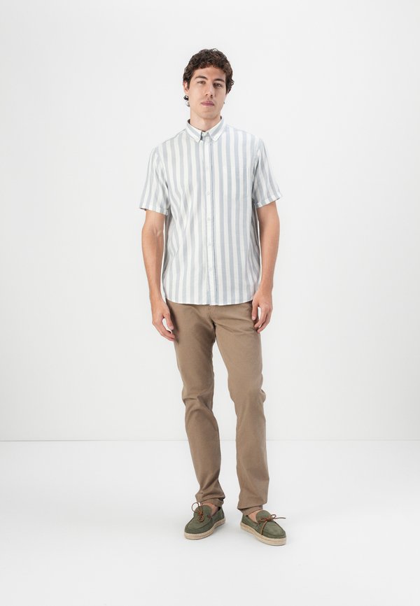 Camisa de botão de manga curta com riscas azul claro e brancas, combinada com calças castanhas e sapatos de camurça verdes com atacadores castanhos.