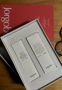 Deux boîtes rectangulaires blanches pour des produits de soin de la peau, étiquetées "Sérum de Niacinamide" et "Hydratant Équilibrant Bio-Actif", dans une boîte blanche.