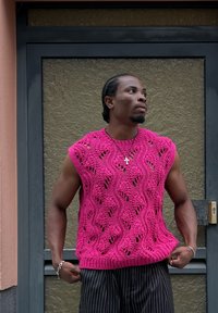 Πλεκτό ροζ αμάνικο πουλόβερ με κυματιστό σχέδιο και κοψίματα. Έχει ριμπ τελείωμα και στρογγυλή λαιμόκοψη.