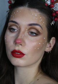 Model mit hellbraunem Haar, geschmückt mit Beeren und silbernen Akzenten. Verfügt über rote Lippen, einen herzförmigen Nasenring und weiße Gesichtspunkten als Bemalung.