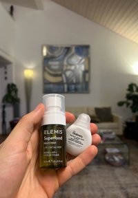 Due prodotti per la cura della pelle: una bottiglia spray in vetro verde etichettata "ELEMIS Superfood Multi Mist" e una bottiglia bianca arrotondata con contagocce etichettata "The Ordinary."