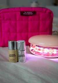 Pink quilted pouch, gold and silver gel polish bottles, and a light pink lamp emitting purple light. Text on bottles states product details.