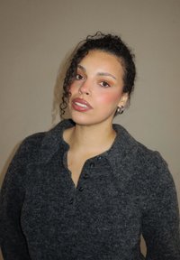 Houtskoolgrijze, wollen pullover met knopen en kraag. Getextureerd oppervlak; heeft een losse pasvorm en subtiele details.