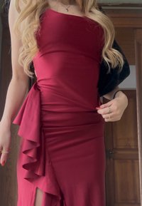Bordó szatén ruha, testhezálló szabással, fodros részletekkel a deréknál és combközépig érő hasítékkal. Puha tapintású, sima felületű anyag.
