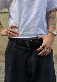 Mustast nahast vöö hõbedase pannaliga, kantud tumeloo siniste teksade kohal. Selle all valge t-särk, kaunistatud mitmete hõbedaste sõrmuste ja käekellaga.