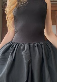 Top negru fără mâneci, cu un corsaj mulat și o fustă voluminoasă, adunată, dintr-un material cu textură. În ansamblu, o siluetă neagră completă.