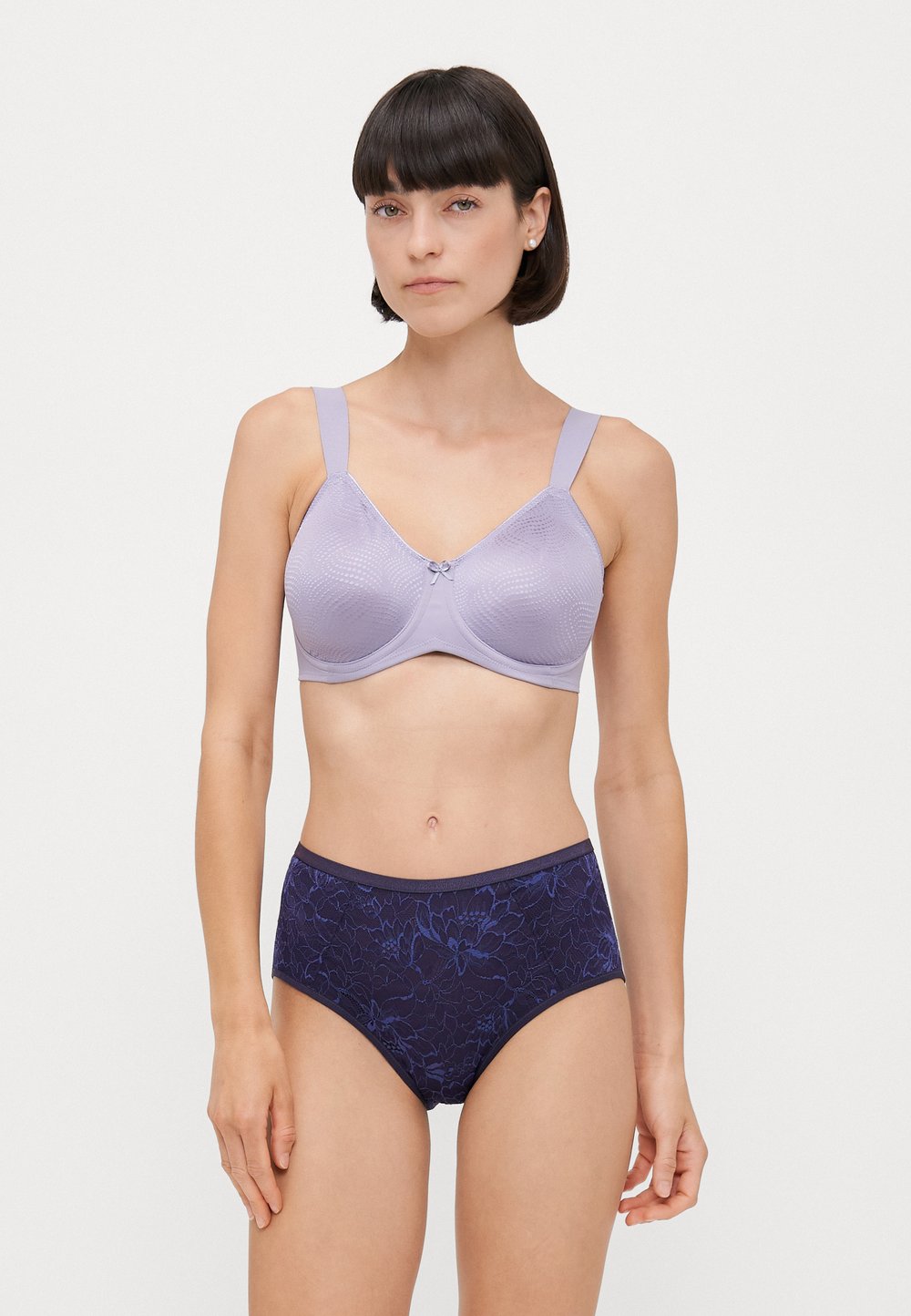 Ανοιχτό μωβ σουτιέν με υφή και κεντρικό φιόγκο, σε συνδυασμό με σκούρα μπλε ψηλόμεσα εσώρουχα με λουλουδένιο μοτίβο.