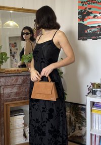 Must mustrilise lillemustriga maksikleit peente rihmadega, mida täiendab väike pruun seemisnahast käekott, millel on ülemine käepide ja klapi sulgur.