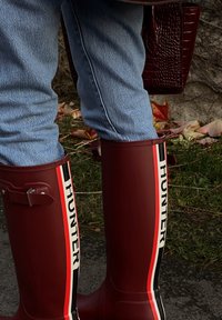 Bordové gumové dažďové topánky s logom a pruhovanými akcentmi v červenej, bielej a čiernej farbe, s detailom bočnej pracky.