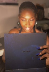 Kwadratowy produkt w granatowym kolorze z błyszczącym wykończeniem, ozdobiony złotymi drobinkami. Nazwa marki "Zarando" jest nadrukowana na powierzchni odwrócona.