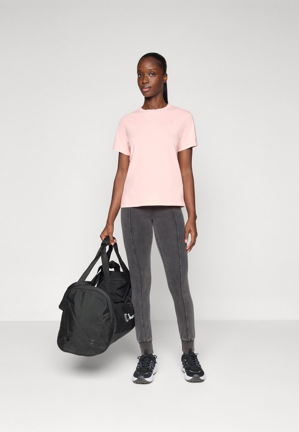 T-shirt rosa a maniche corte, leggings grigi con cuciture laterali, borsa da palestra nera e scarpe sportive nere con dettagli bianchi.