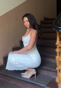 Hvit blondkjole med tynne stropper, knelengde, med et strukturert mønster. Beige høye hæler med slingback-design.