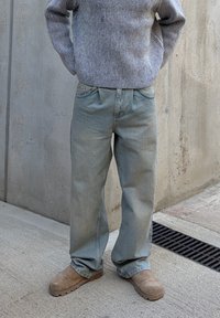 Ljusblå jeans i denim med avslappnad passform, som har knapp- och dragkedjefly, framfickor och lätt fransiga fållar. Matchas med en randig tröja.