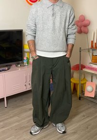 Hall hallitatud polo kampsun kraega, mille juurde on kombineeritud laiad, tumerohelised püksid. Kandmiseks valitud hõbedased spordijalanõud.