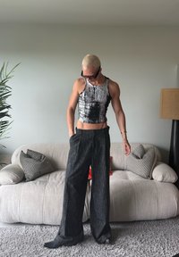 Srebrni i crni crop top s teksturiranim uzorkom, uparen s labavim crnim hlačama. Moderni estetski izgled nadopunjen elegantnom crnom obućom.