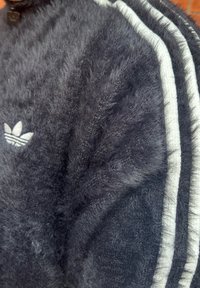 Bolygós tengerészkék pulóver fehér adidas csíkokkal, texturált felülettel és bal oldali mellrészen hímzett logóval.