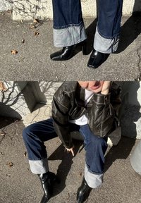 Ciemne dżinsy z szarą mankietem, zestawione z czarnymi botkami na kwadratowym nosku. Na białej bluzce noszona jest czarna skórzana kurtka.